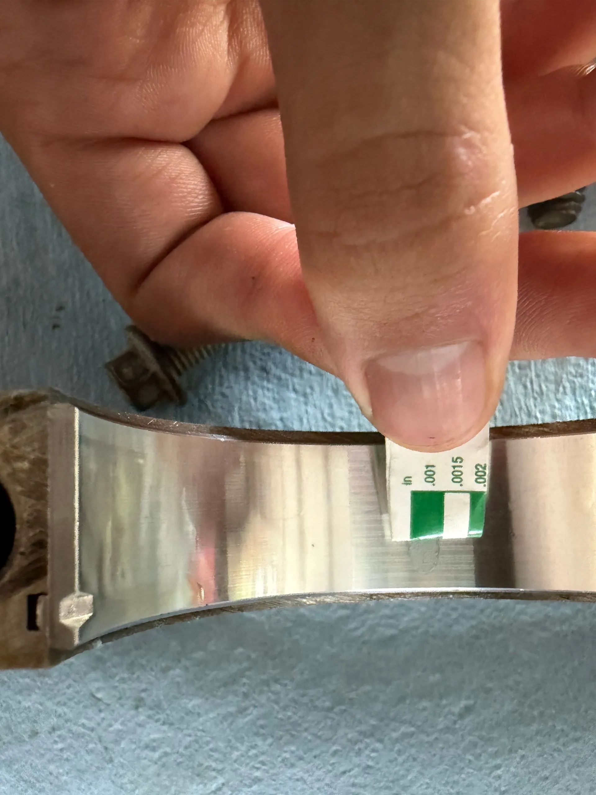 A strip of Plastigage being placed on a bearing shell